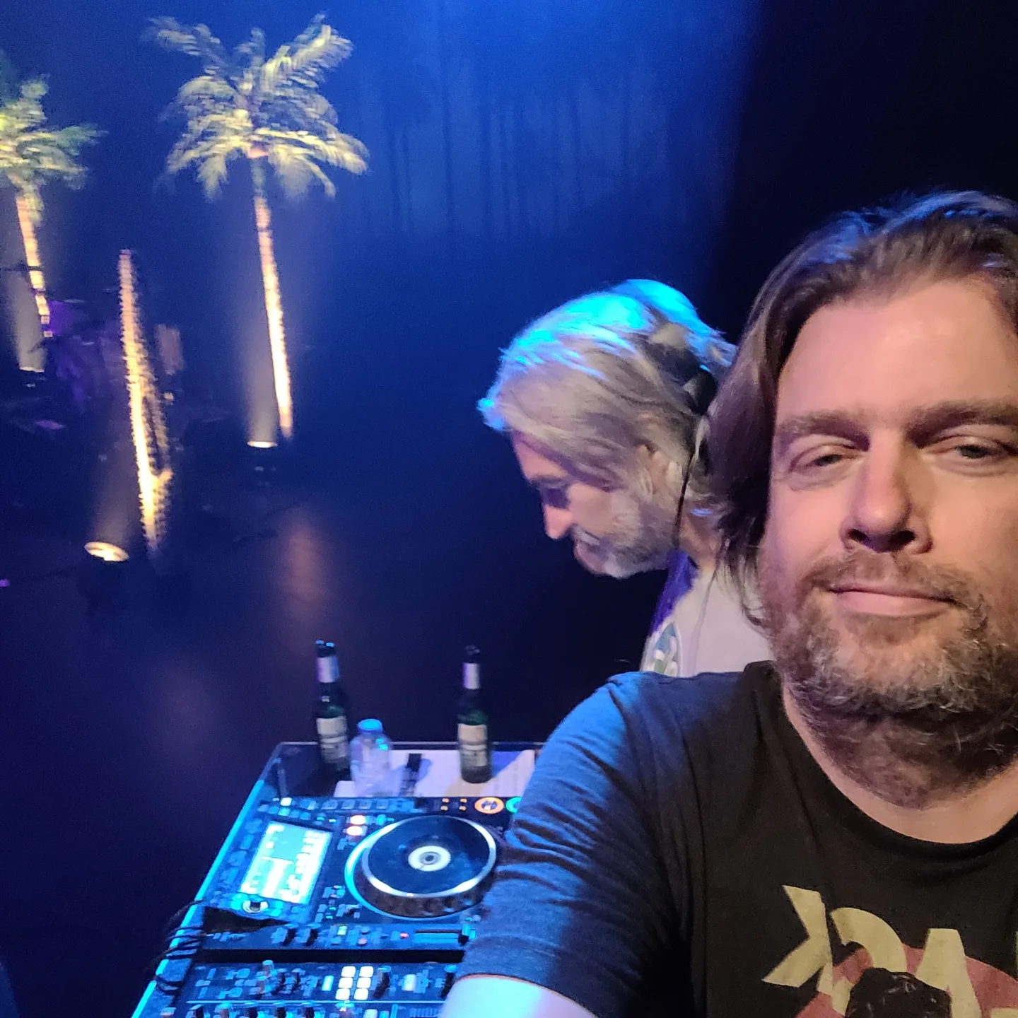 Disco Suave achter de CDJ&rsquo;s met palmbomen op de achtergrond
